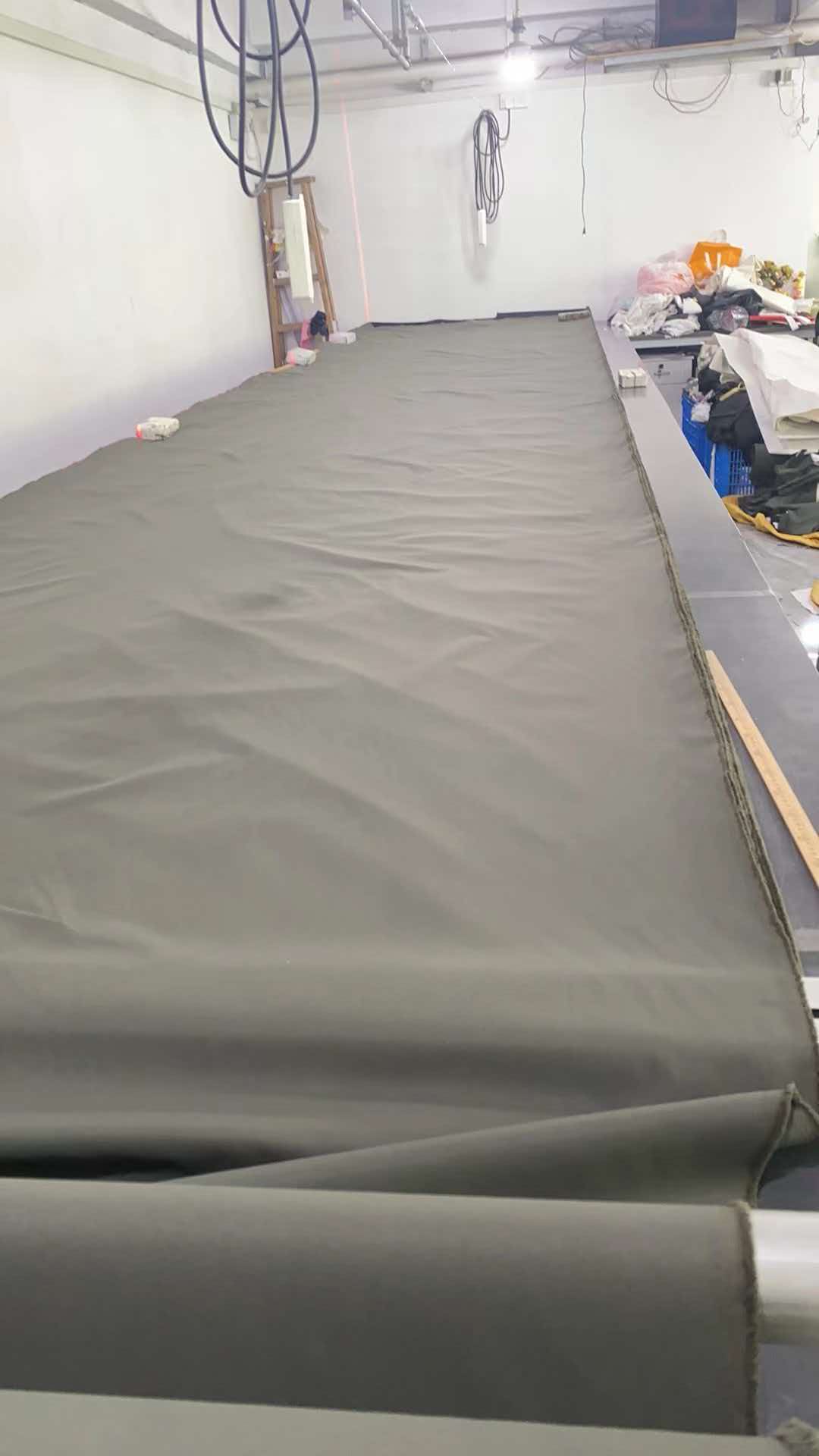 Fabric spread across a long cutting table at the Guangzhou production location